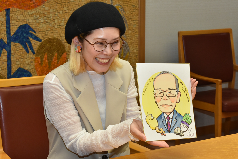 市長の似顔絵を差し出す浜田さん