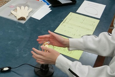 エジソン電球に手をかざして、温かさを実感