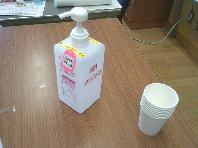 洗口液のボトルと紙コップ