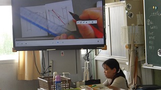 点対称の特性を、担任は拡大モニタを使い理解の支援をしています