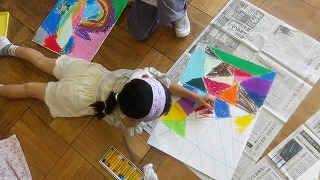 教室では子供たちが好きな色を画用紙に敷き詰めるように塗っています
