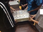 1億円のレプリカを持ち上げる
