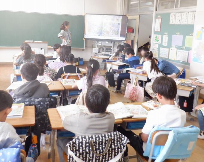 電子黒板を見ながら先生の話を聞いています