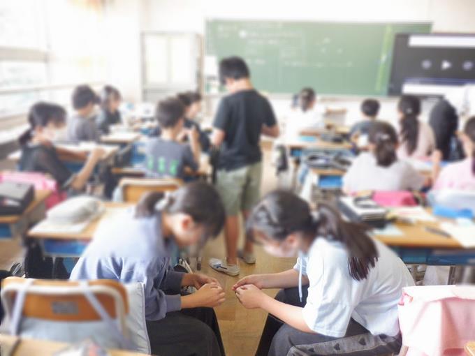 5年生家庭科　玉結びを教え合っています