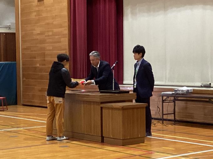 代表児童が前期の通知表を受け取りました。